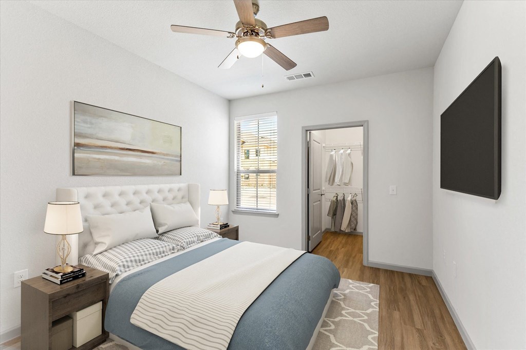 a bedroom with a large bed and a ceiling fan