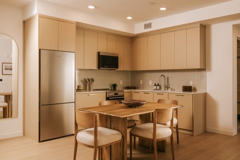 A kitchen with a table and chairs.