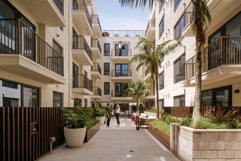 Two people walking down a path between buildings.