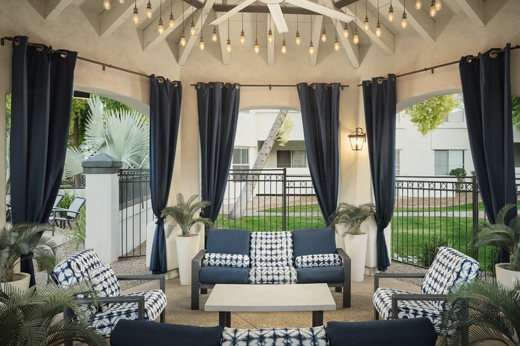 a patio with blue and white chairs and a white coffee table