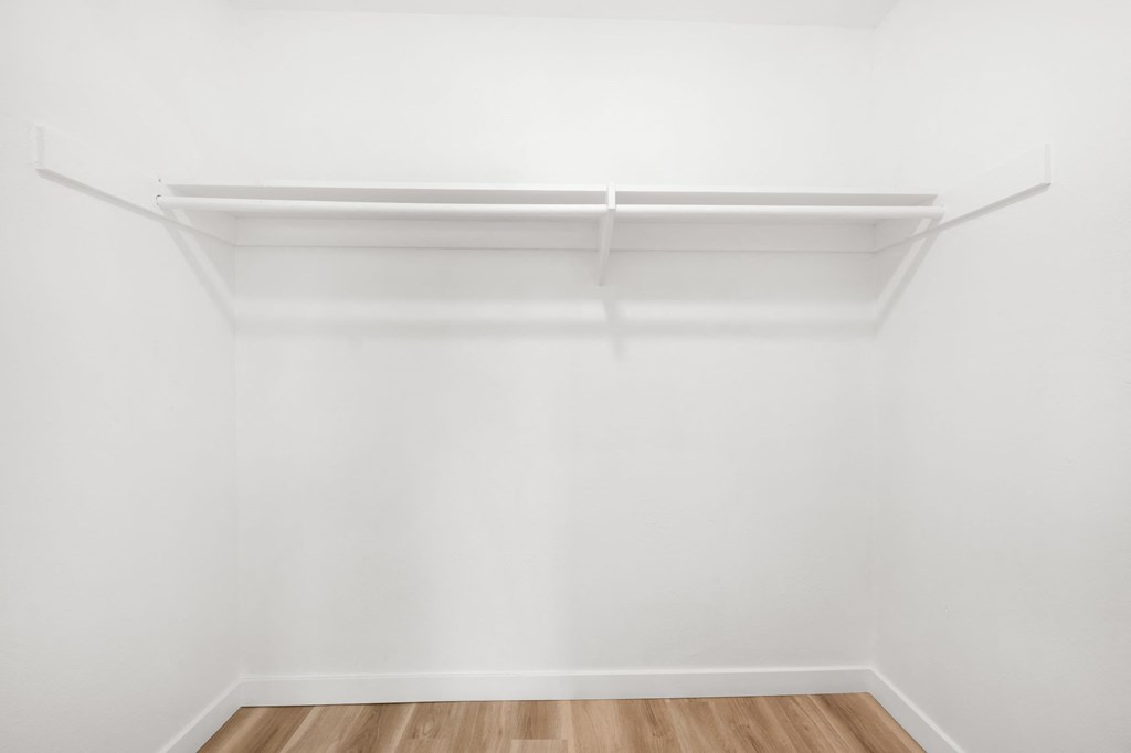 an empty room with white walls and a wooden floor