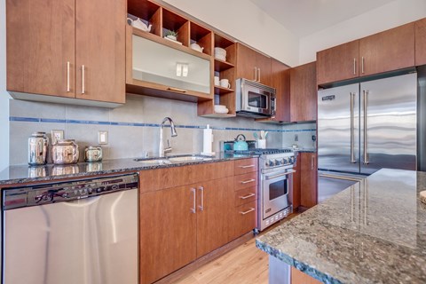 A kitchen with wooden cabinets and granite countertops.