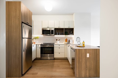 A modern kitchen with wooden cabinets and stainless steel appliances.