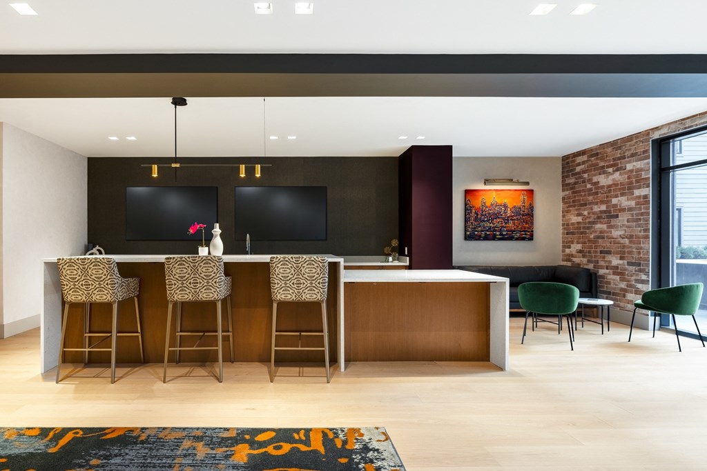 a kitchen with a bar and chairs and a brick wall