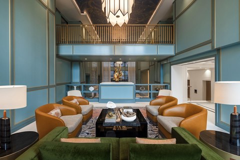 A living room with a green carpet and a coffee table in the middle.