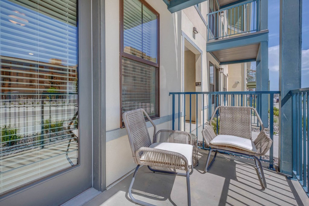 a balcony with two chairs and a table