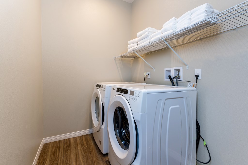A white dryer and washer are in a small laundry room.