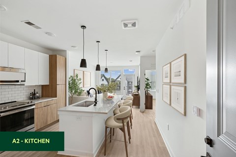 A modern kitchen with a large island and pendant lights.