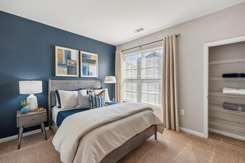 A bedroom with a large bed and a wooden nightstand.