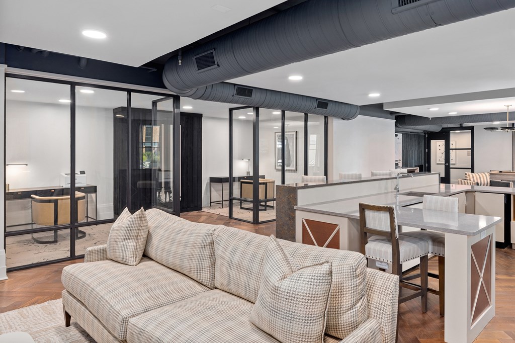 A modern living room with a checkered sofa and a kitchen area in the background.