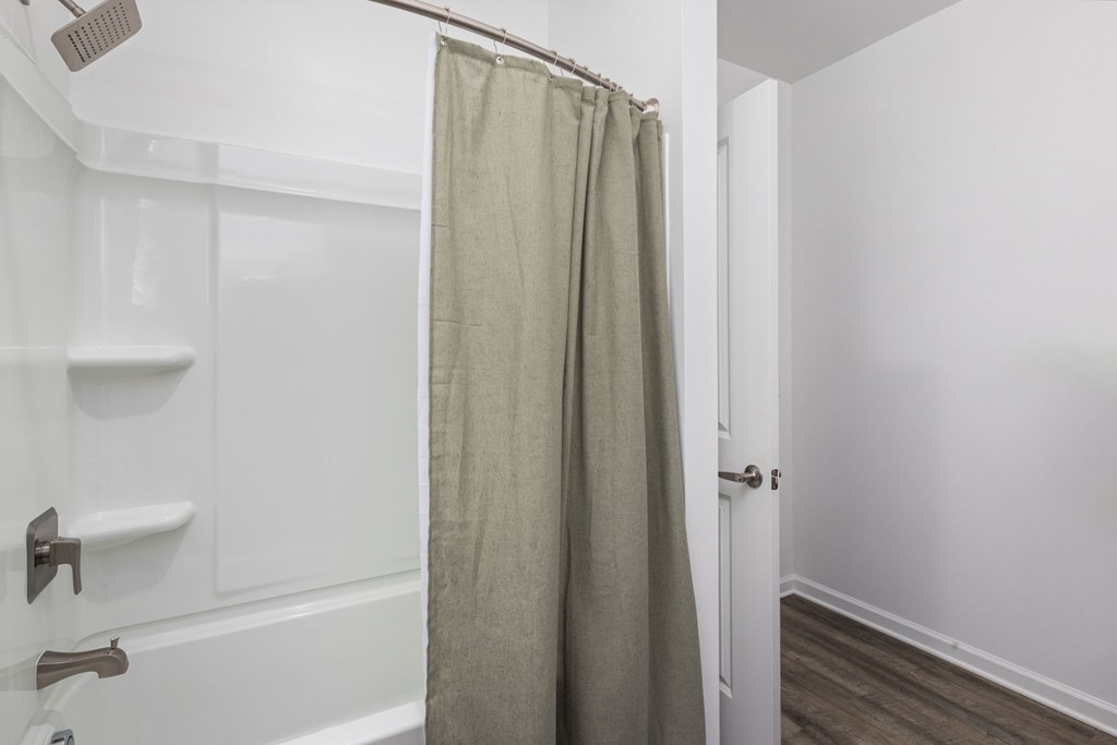 A white bathroom with a shower curtain.