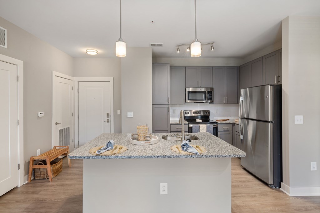 A kitchen with a granite countertop and stainless steel appliances.