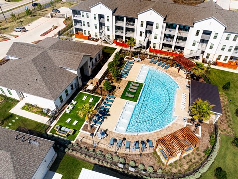 An aerial view of a resort with a swimming pool and loungers.