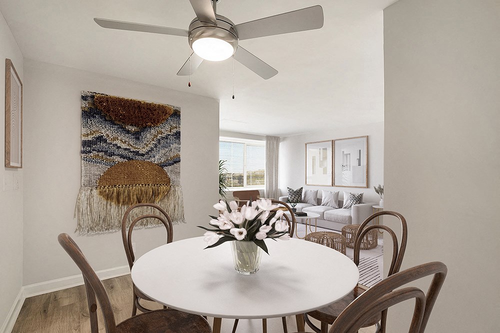 a living room with a dining table and a ceiling fan