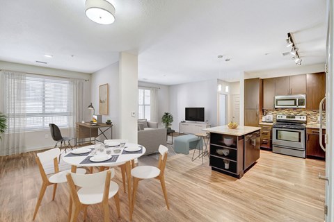 A modern kitchen with a dining table and chairs.