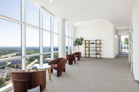 A room with a long table and chairs with a view of the city.