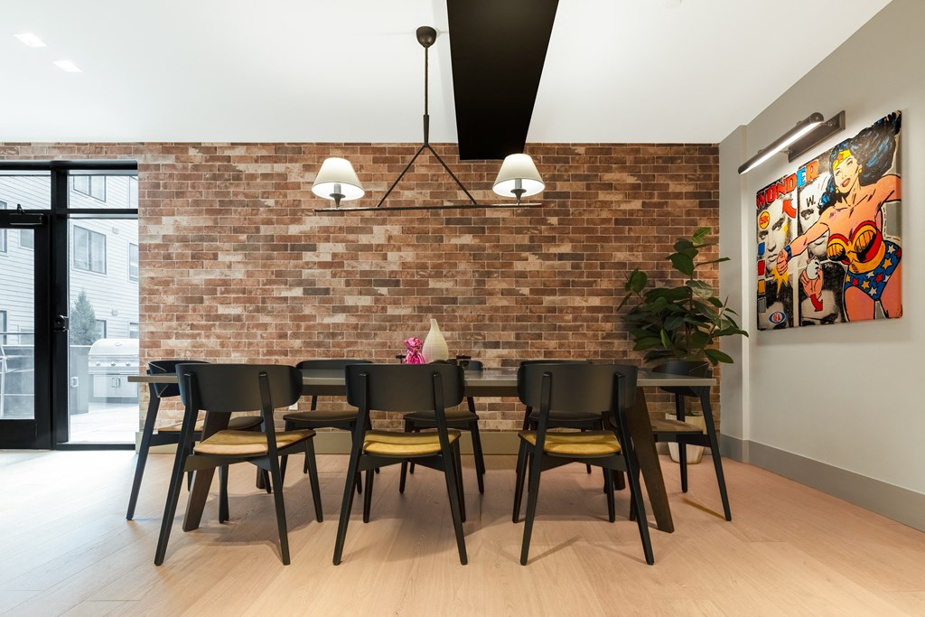 a dining room with a brick wall and a table with chairs