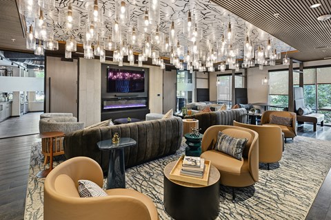 A modern lounge area with a large screen TV and comfortable seating.