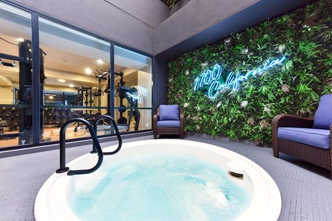 A hot tub sits in the middle of a room with a green wall behind it. at 1700 California Street, San Francisco, CA