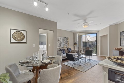 A dining room with a table set for four and a view of the backyard.