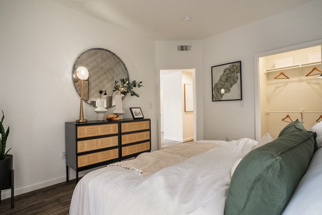 a bedroom with a bed and a dresser with a mirror