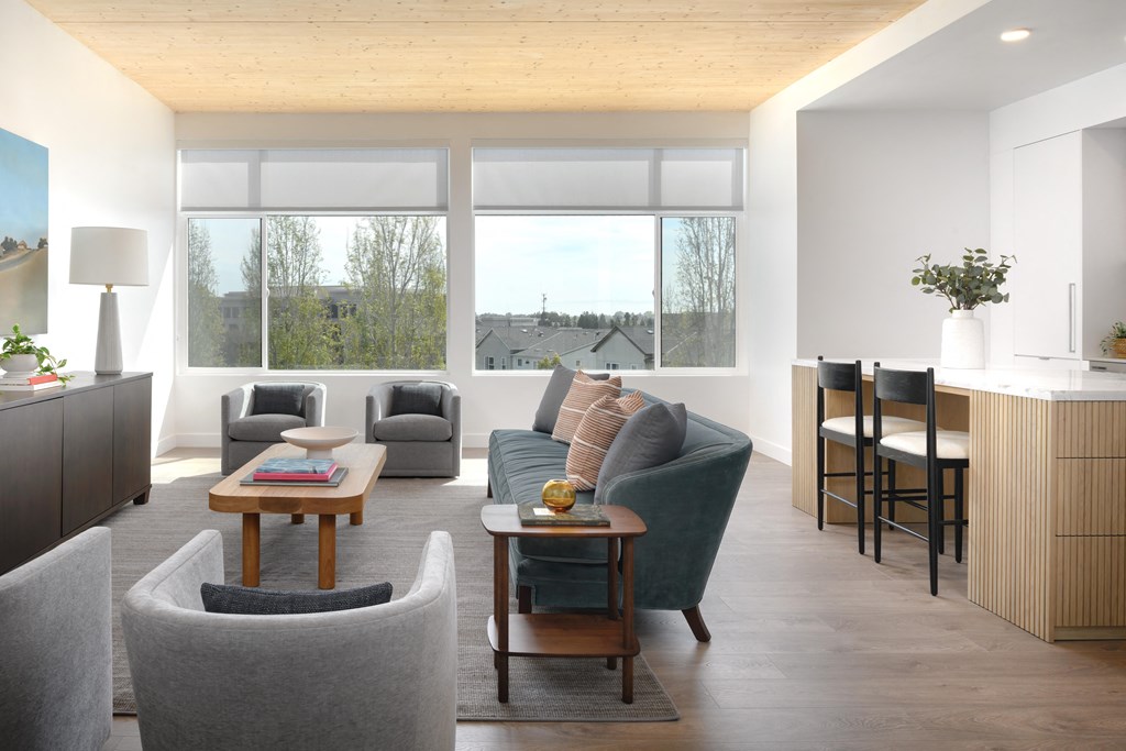 a living room with couches and chairs and a kitchen with a table and chairs