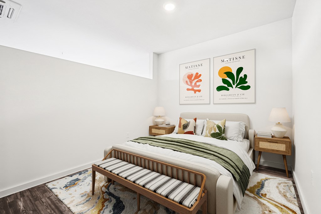 a bedroom with white walls and a bed with a green and white blanket
