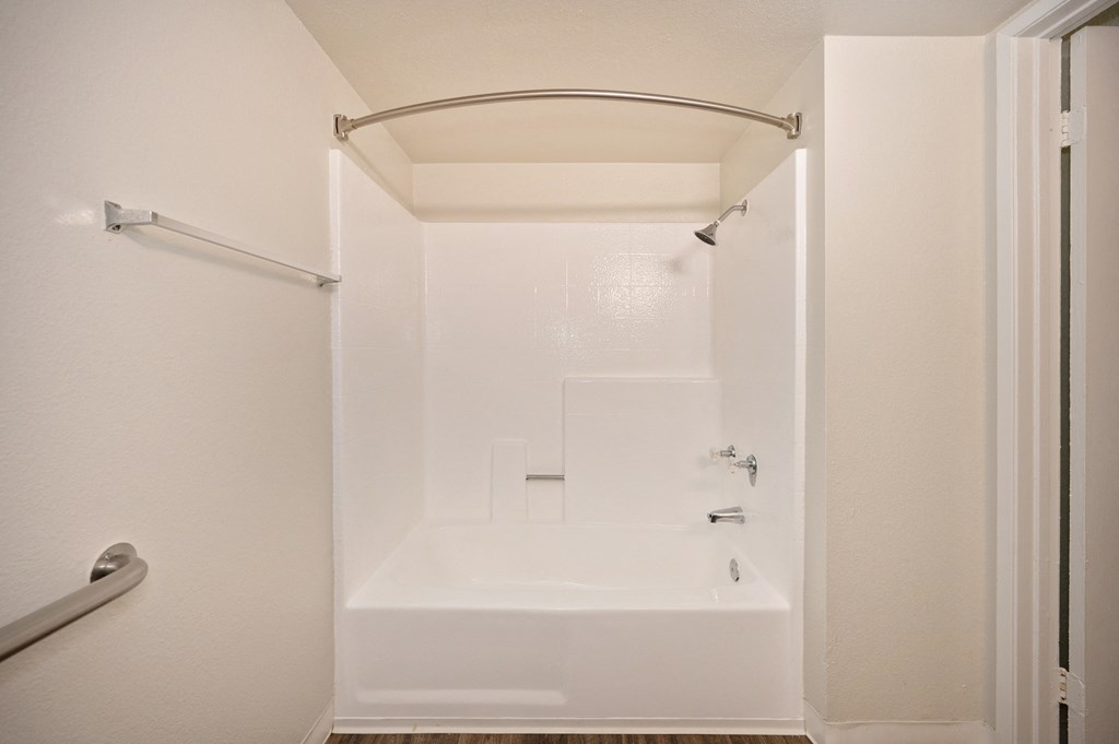 a studio apartment bathroom with a shower and tub