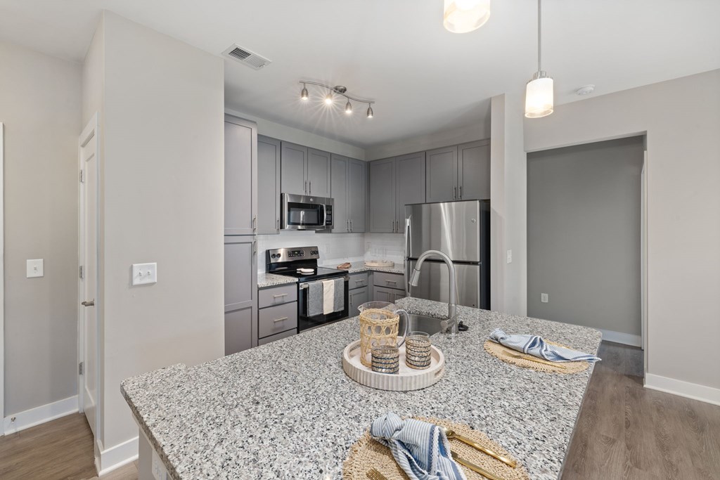 A kitchen with granite countertops and stainless steel appliances.
