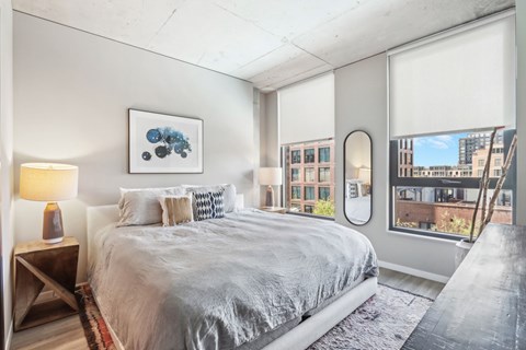 A bedroom with a large bed and a view of the city.