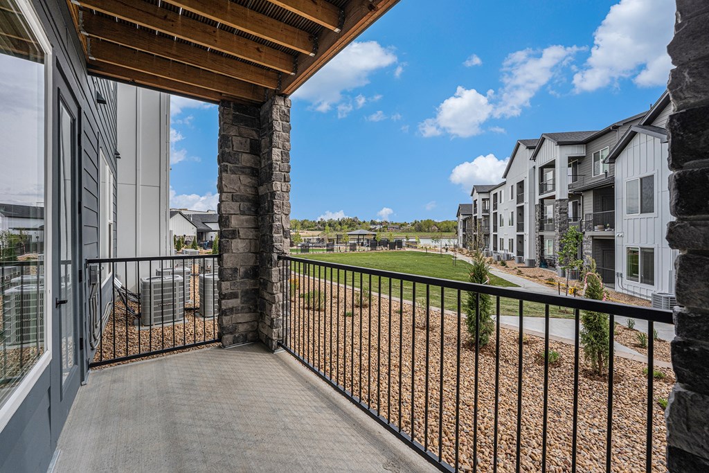 the view from the balcony of an apartment building with a yard and other apartment buildings