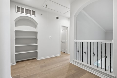 A white room with a balcony and shelves.