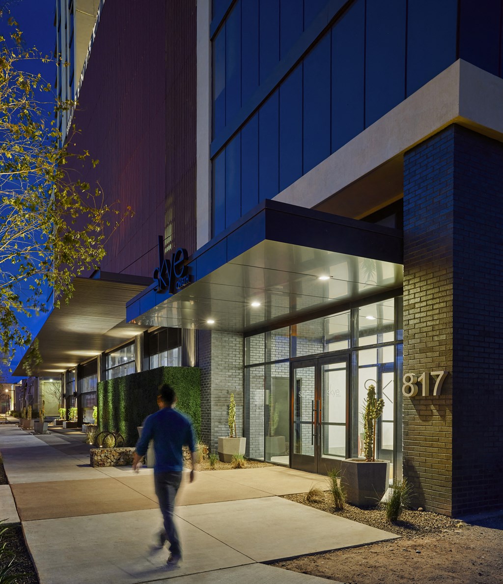 a man walking in front of a building at night