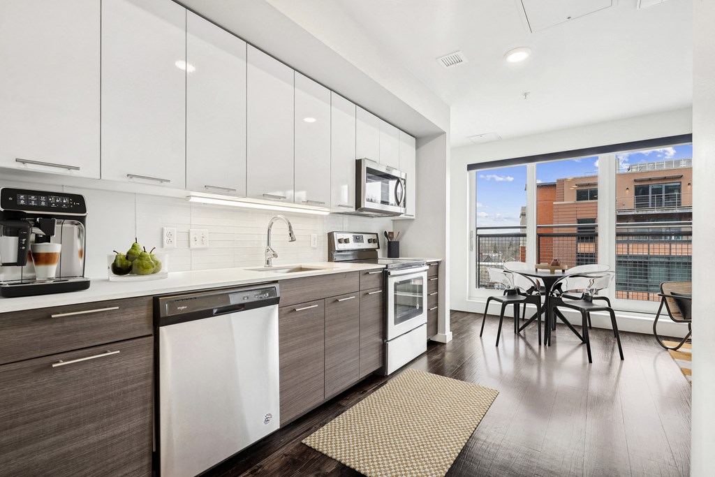 a kitchen with white cabinets and stainless steel appliances and a window
