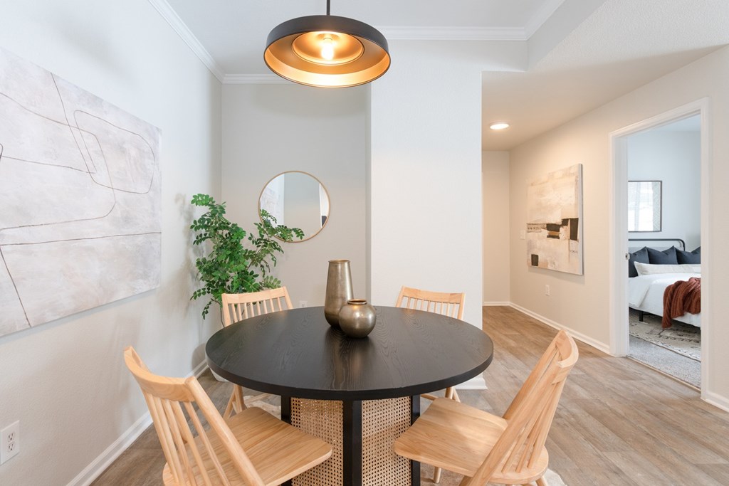 A dining room with a round table and chairs.