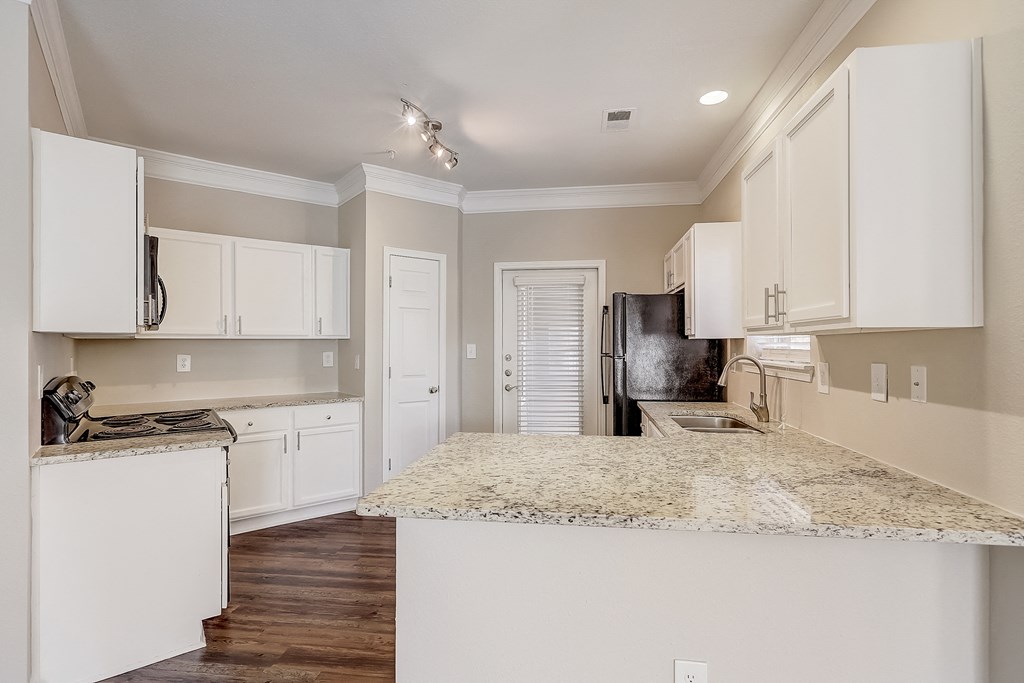 a kitchen with white cabinets and a granite counter top