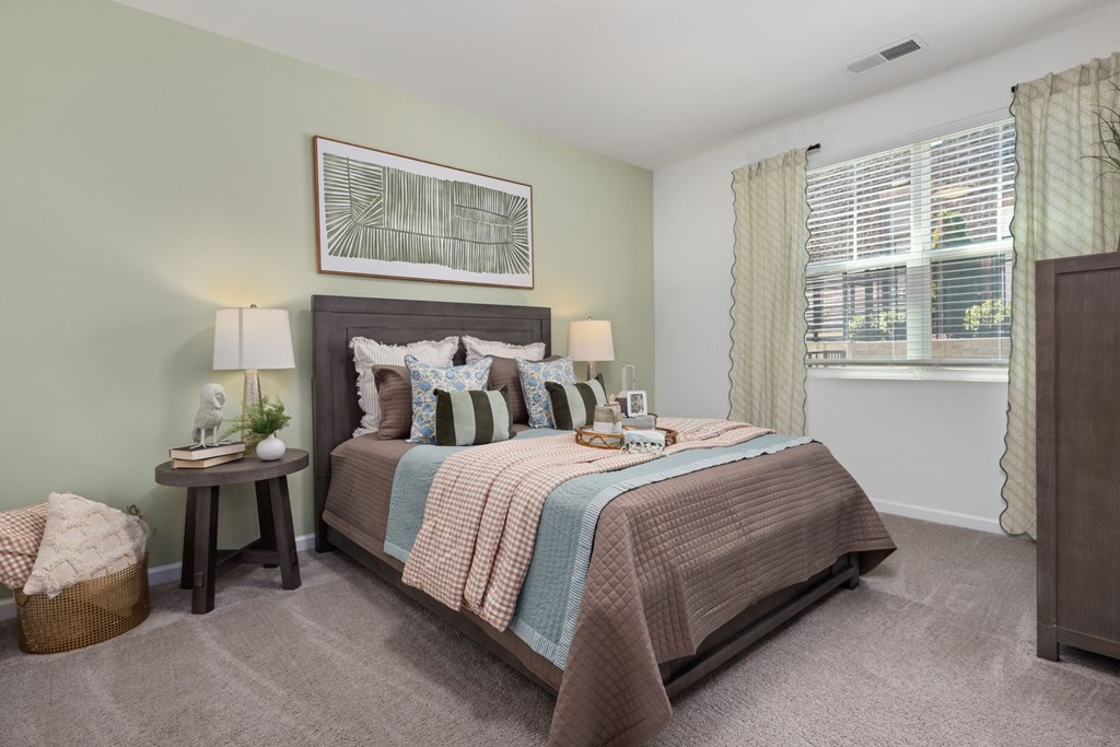 A bedroom with a large bed and a painting on the wall.