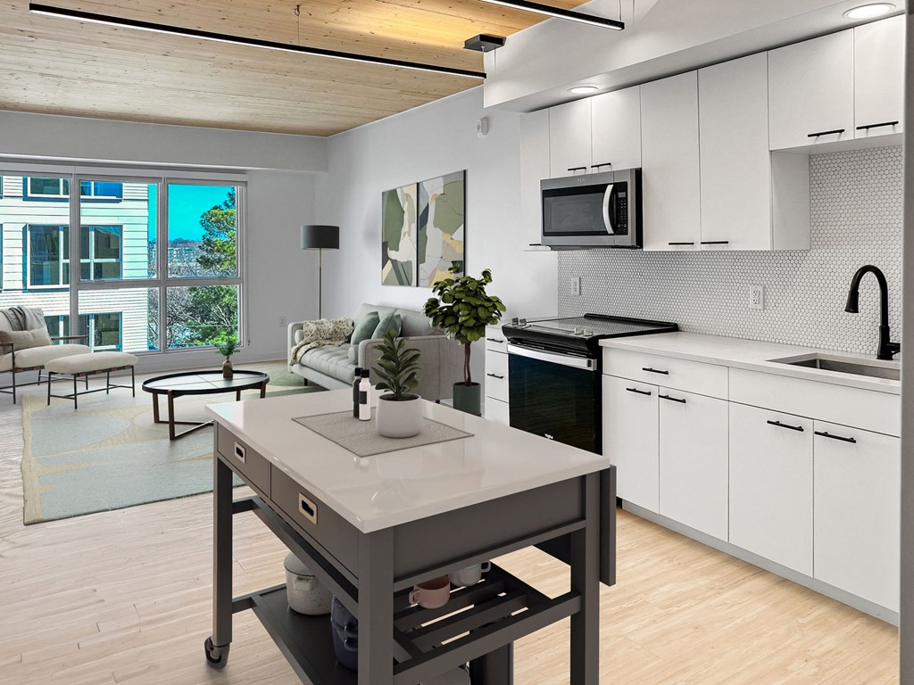 a kitchen and living room with white cabinets and a table
