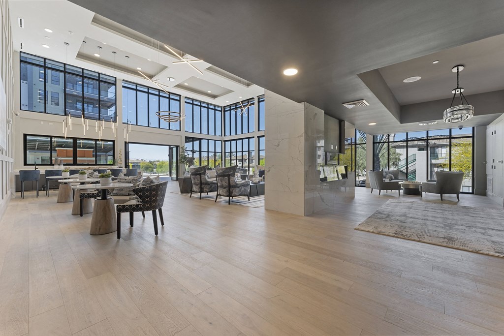 the lobby of a building with tables and chairs and large windows