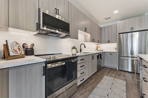 A modern kitchen with a stainless steel refrigerator and oven.