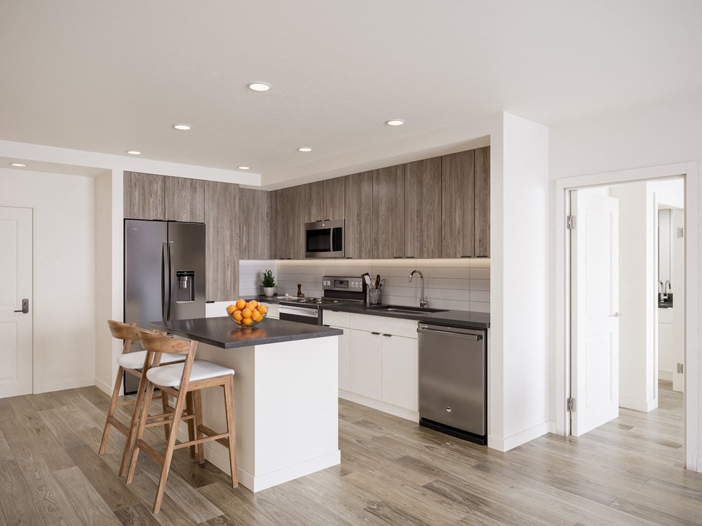 a kitchen with a island and a stainless steel refrigerator