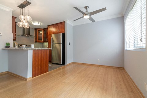 A kitchen with wooden cabinets and a stainless steel refrigerator.