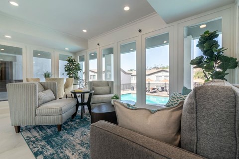 A living room with a couch, chairs, and a table with a potted plant on it.