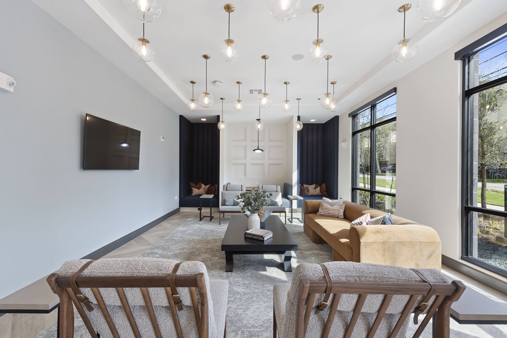 A modern living room with a large window and a grey rug.