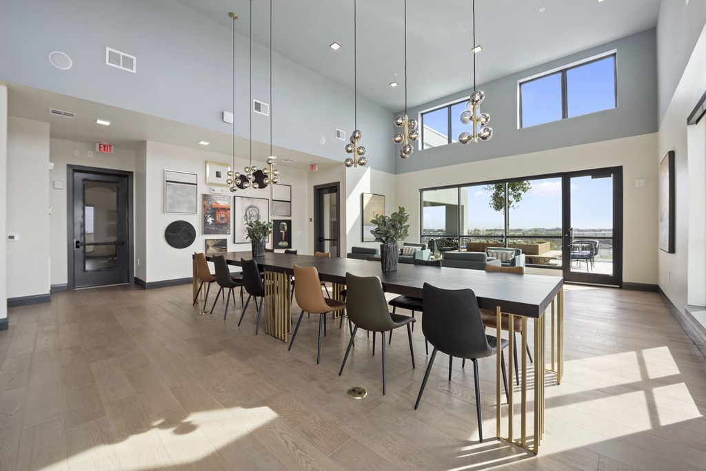 A modern dining room with a long table and chairs.
