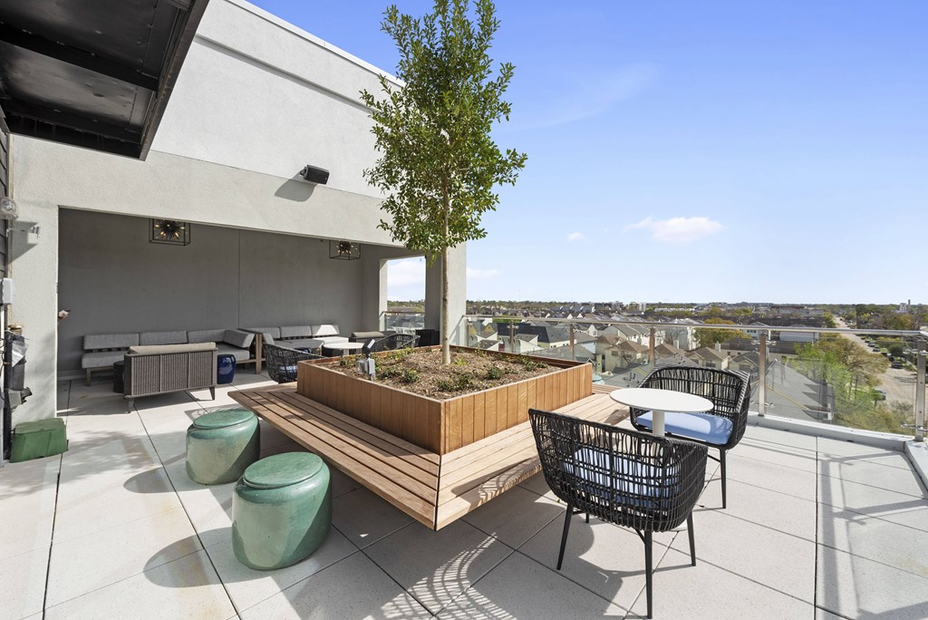 A patio with a table and chairs overlooking a cityscape.