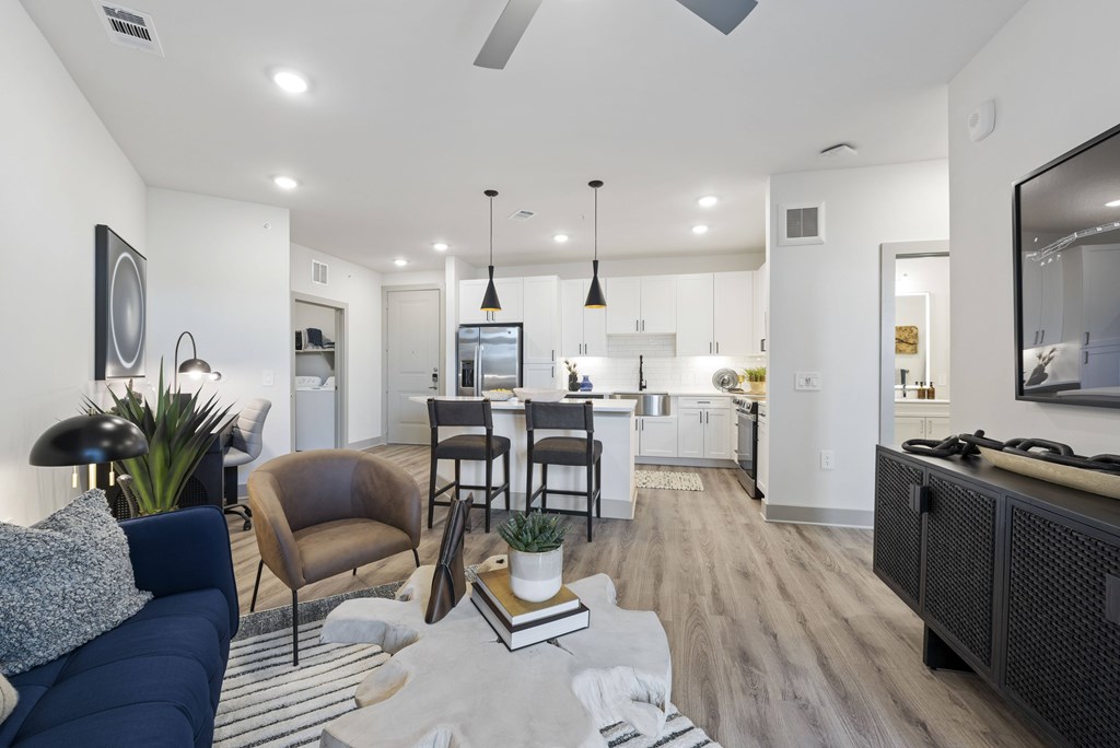 A modern living room with a dark blue sofa and a grey rug.