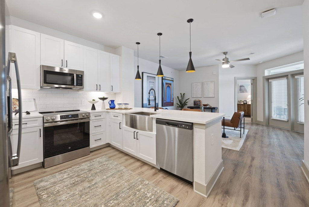 A modern kitchen with white cabinets and stainless steel appliances.