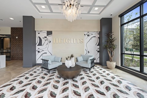 A living room with a rug on the floor and a chandelier hanging from the ceiling.