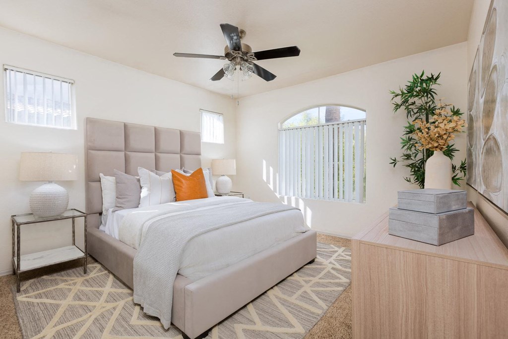 a bedroom with a large bed and a ceiling fan